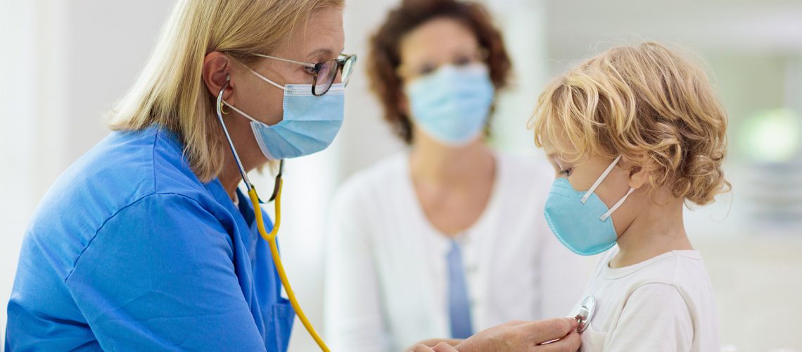 Pediatrician doctor examining sick child in face mask. Ill boy in health clinic for test and screening. Kids home treatment of virus. Coronavirus pandemic. Covid-19 outbreak. Patient coughing.